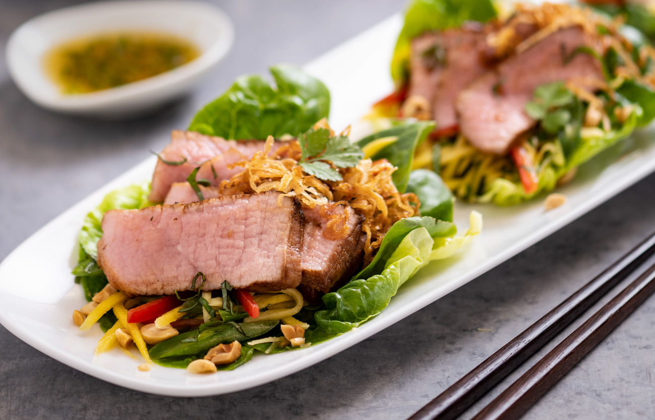 Gem lettuce topped with green mango salad, peanuts, fried shallots and grilled veal dressed in chili lime vinaigrette